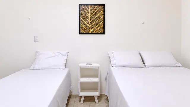Ambiente de suíte com duas camas e janela