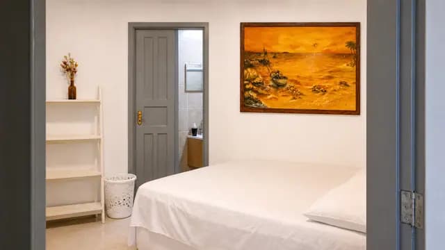 Suíte clara com cama e acesso ao banheiro