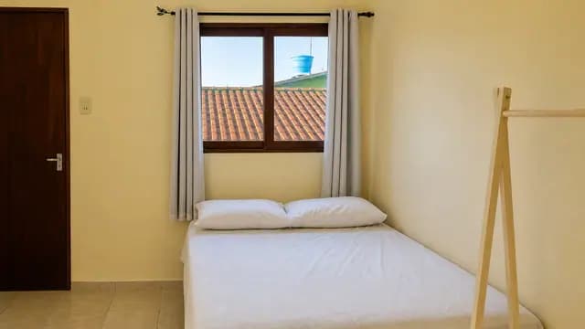 Quarto com cama, janela e cabideiro