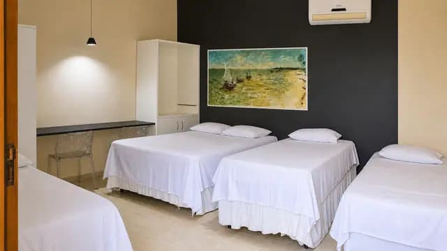 Ambiente de suíte com três camas e climatização